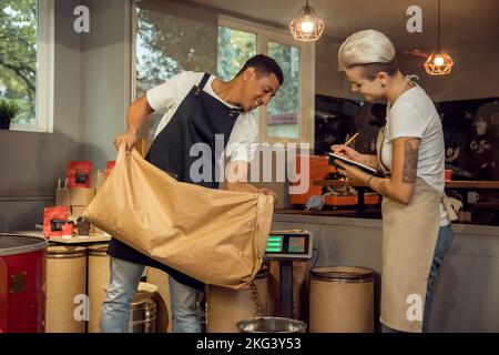 Personale che misura il peso di un prodotto sulla bilancia Foto Stock