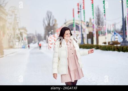 Felice donna sorridente sta pattinando all'aperto. Festa umore, buon Natale concetto. I sogni diventano il vero concetto. Foto Stock