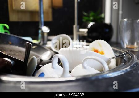 Molti piatti sporchi nel lavandino in cucina Foto Stock