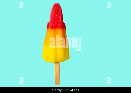 Brillante fotografia colorata di un rosso, arancione e giallo razzo a forma di ghiaccio Lolly Possicle con bastone di legno isolato su uno sfondo blu pallido con copia Foto Stock
