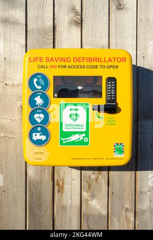 Defibrillatore dispositivo salvavita di emergenza UK defibrillatore in un alloggiamento giallo sicuro a parete per uso di emergenza solo Inghilterra UK GB Europa Foto Stock