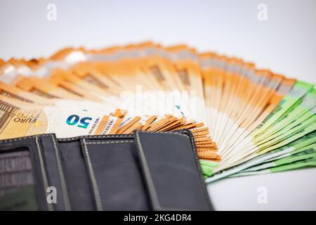 Primo piano delle banconote in euro in un ventilatore con borsetta tagliata su sfondo bianco Foto Stock