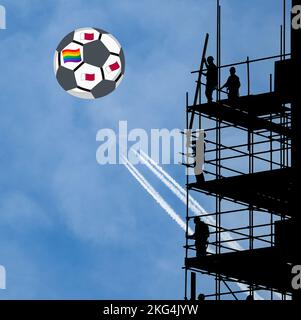 Operai edili con bandiera arcobaleno e bandiere del Qatar sul calcio. Coppa del mondo, LGBTQ, gay, diritti umani, FIFA...concetto Foto Stock