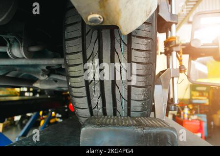 Primo piano di un nuovo battistrada di pneumatico di un'auto in un negozio di pneumatici auto, servizio di manutenzione automobilistica concetto di business Foto Stock