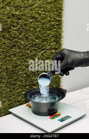 Un parrucchiere versa un ossidante. Il processo di preparazione prima di colorare i capelli Foto Stock