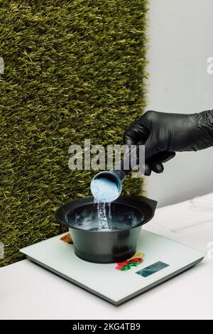 Un parrucchiere versa un ossidante. Il processo di preparazione prima di colorare i capelli Foto Stock