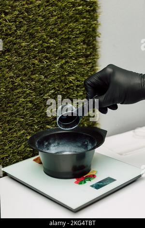 Un parrucchiere versa un ossidante. Il processo di preparazione prima di colorare i capelli Foto Stock