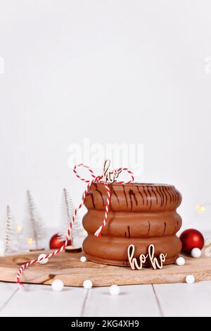 Torta di spiedo a strati chiamata 'Baumkuchen' glassata con cioccolato di fronte alla decorazione stagionale di Natale Foto Stock