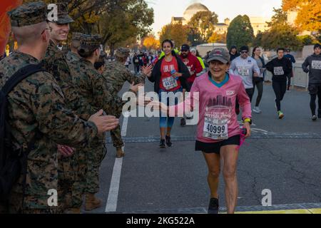 Pamela Stratos, un partecipante alla Maratona del corpo Marino 10k corre attraverso la linea di partenza mentre incoraggiato da U.S. Marines al National Mall di Washington, D.C. il 30 ottobre 2022. Nota come la migliore maratona per i principianti, la MCM è la più grande maratona del mondo che non offre premi in denaro, guadagnando il suo soprannome, “la maratona del popolo”. I corridori di tutti i livelli hanno partecipato al MCM10K. Foto Stock