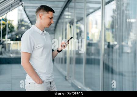 uomo d'affari con un telefono in mano sulla strada Foto Stock