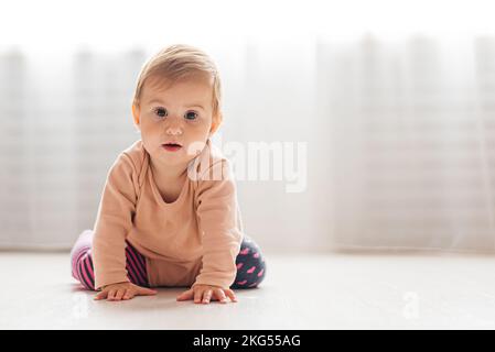 Bambina che gioca con piramide sul pavimento, asilo, precocità Foto Stock