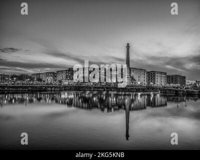 Scene di strada a Liverpool visto qui dall'area di Albert Dock guardando attraverso il molo al vecchio camino del molo pompa edificio Foto Stock