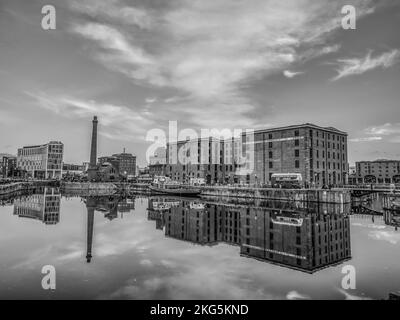 Scene di strada a Liverpool visto qui dall'area di Albert Dock guardando attraverso il molo al vecchio camino del molo pompa edificio Foto Stock