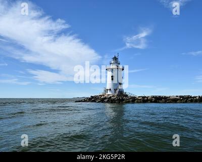 Un faro bianco con un suggestivo sfondo di nuvole a ventaglio in un cielo blu Foto Stock