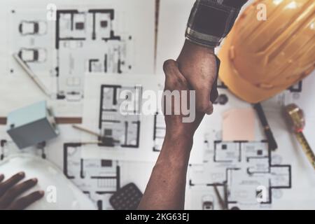 Architetti e ingegneri addetti alle costruzioni che si scuotono le mani dopo aver concluso un accordo nel sito di costruzione di uffici, concetto di collaborazione di successo Foto Stock