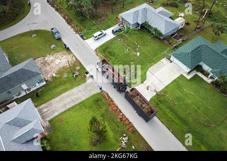 Vista aerea dell'uragano Ian speciale camion di recupero post-matematica raccogliendo detriti di vegetazione dalle strade suburbane della Florida. Gestione Foto Stock