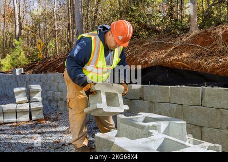 Un appaltatore stava installando pareti in blocchi di calcestruzzo su un progetto di costruzione di pareti di fissaggio nuovo. Foto Stock