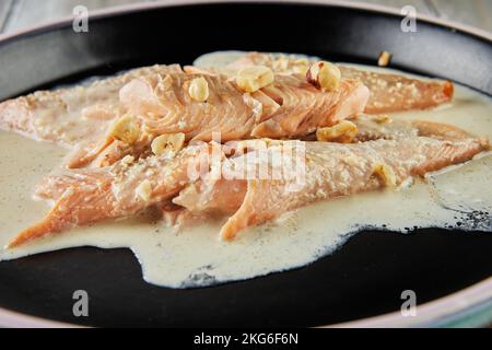 Pesce trota con nocciole e salsa di panna cotta al forno. Cucina francese gourmet. Foto Stock