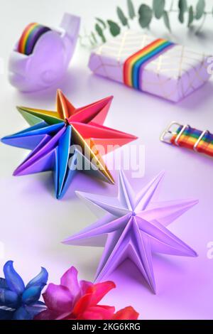 Vibranti stelle di carta origami al neon arcobaleno. LGBTQ Community arcobaleno bandiera colori. Fatto a mano DIY decorazione natalizia. Le stelle di Natale fatte da sé sono fatte da vibrante Foto Stock