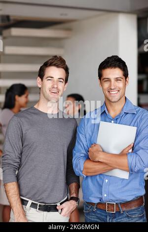 Soddisfatto del lavoro che theyre produce. Ritratto di due collaboratori creativi in piedi insieme in ufficio dopo un incontro di successo. Foto Stock