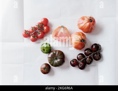 Ancora vita varietà di pomodori su sfondo bianco Foto Stock