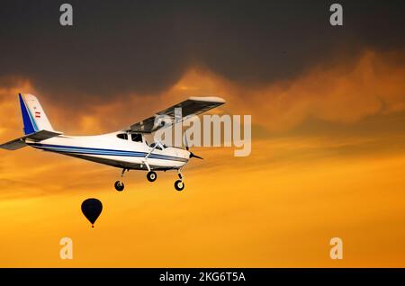 Bellissimo scatto di un velivolo ultraleggero a motore singolo che vola sotto il cielo del tramonto Foto Stock