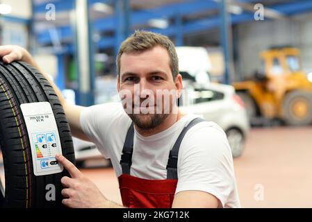 Economia adesivo con valori di consumo su un nuovo pneumatico auto - cambio gomme in officina mediante mezzi meccanici Foto Stock