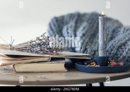 Composizione casalinga accogliente con libri in primo piano sul tavolo. Foto Stock