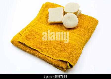 bellissimo asciugamano pulito e saponi naturali fatti a mano su uno sfondo bianco, spa, hotel, wellnes Foto Stock