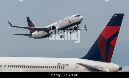 Richmond, British Columbia, Canada. 21st Nov 2022. Un Boeing Air Canada 737 MAX 8 Jetliner (C-GEKZ) parte dall'aeroporto internazionale di Vancouver. Nell'area anteriore, un Boeing 757 della Delta Air Lines (N650DL) è parcheggiato presso il terminal sud dell'aeroporto. (Credit Image: © Bayne Stanley/ZUMA Press Wire) Foto Stock