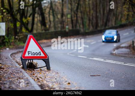 Un triangolo di alluvione sul lato di Elland Road, Brighouse, West Yorkshire, Regno Unito come gli utenti della strada guidano oltre esso in una mattinata autunnale con le foglie umide a lato della strada.Credit: Windmill Images/Alamy Live News Foto Stock