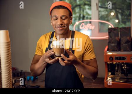 L'addetto al caffè ha apprezzato l'odore di caffè nel bicchiere Foto Stock