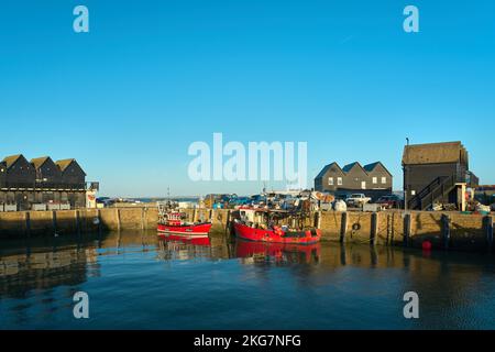 Whitstable, Kent, Regno Unito - 6 2022 ottobre - due barche rosse a Whitstable Harbour Foto Stock