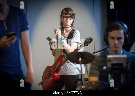 studente di una scuola secondaria suona la chitarra durante una lezione di musica. olanda. vvvbvanbree fotografie . Foto Stock