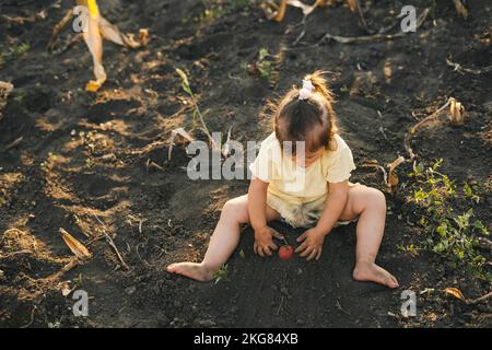 Adorabile bambina imparando come piantare i semi nel terreno alla serra. Persona positiva. Divertimento per tutta la famiglia. Foto Stock