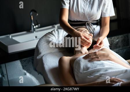 Donna giovane e sana nel salone termale. Massaggi tradizionali e trattamenti di bellezza. Foto Stock