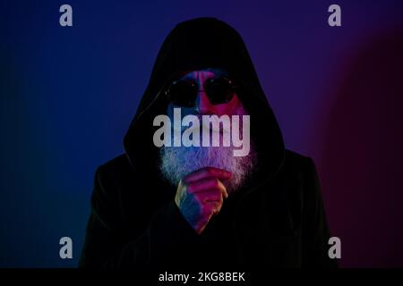 Foto di un uomo sospettoso vestito abiti neri decidi di rubare babbo natale rovinare l'evento di Natale isolato su sfondo di colore sfumato scuro Foto Stock