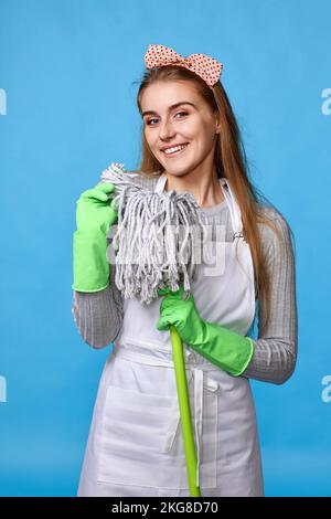 donna in guanti di gomma e grembiule più pulito che tiene il mop Foto Stock