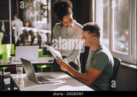 Allegra impiegato che mostra documenti al suo capo Foto Stock