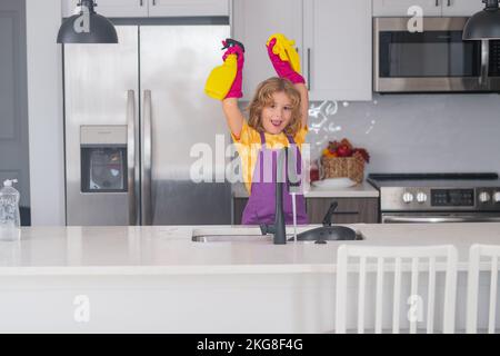 Bambino che fa i lavori di casa. Ritratto di pulizia del bambino nel kithen a casa, la crescita del concetto, lo sviluppo, le relazioni familiari. Cute Funny ragazzo lavaggio Foto Stock