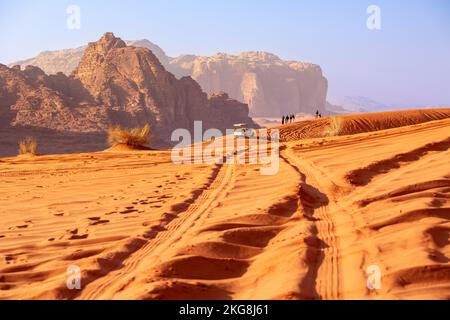 Giordania, Wadi Rum - 2 novembre 2022: Jeep safari nel deserto. Turisti e fuoristrada percorrono le dune di sabbia e il bellissimo paesaggio roccioso Foto Stock