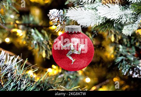 Natale Isola di Man. Albero di natale con neve, decorazioni e una bandiera.  Boschi innevati background in inverno. Natale biglietto di auguri Foto  stock - Alamy