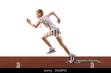 Giovane atleta, runner di pista femminile principiante scoppiare fuori blocco di partenza isolato su sfondo bianco. Sport, allenamento, abilità. Allenamento bambina Foto Stock