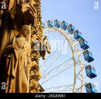 Ruota panoramica di Natale di fronte alla cattedrale di Metz . Dettaglio architettonico - statua di donna con gli occhi coperti. Metz, Francia. Concetti astratti. Foto Stock