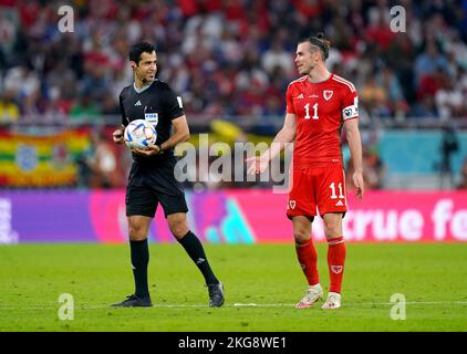 Gareth Bale, in Galles, parla con l'arbitro Abdulrahman al-Jassim durante la partita di Coppa del mondo FIFA di Gruppo B allo stadio Ahmad Bin Ali, al-Rayyan. Data immagine: Lunedì 21 novembre 2022. Foto Stock