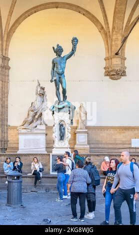Statua di Perseo con testa tagliata di Medusa, di Cellini,1554 - con turisti Loggia del Lanzi, Piazza della Signoria, Firenze, Italia Foto Stock