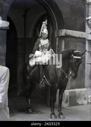 1950s, storico, una guardia di cavalli montata all'ingresso cerimoniale di St James e Buckingham Palace, il quartier generale della Household Cavalry Mounted Regiment, Westminster, Londra, Inghilterra, Regno Unito. Foto Stock