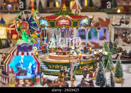 Allegra giostra in miniatura con personaggi giocattolo nel parco invernale durante il mercatino di Natale Foto Stock