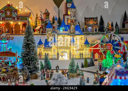 Castello in miniatura, ruota panoramica e giostra con personaggi giocattolo nel parco invernale durante il mercatino di Natale Foto Stock