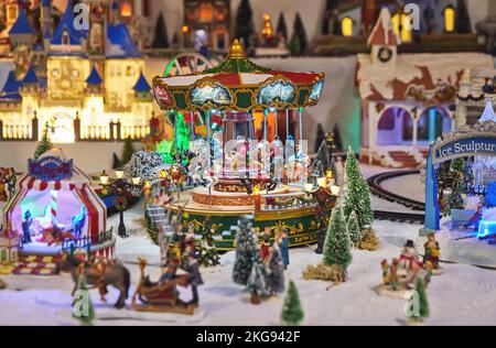 Allegra giostra in miniatura con personaggi giocattolo nel parco invernale durante il mercatino di Natale Foto Stock